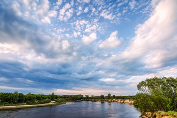 Fototapeta na wymiar Landscape with a river and clouds in a blue sky