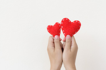 Two hand holding two red heart on white background. Happy, Love, Valentines day idea, sign, symbol, concept.