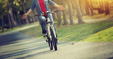 Fototapeta na wymiar happy woman cyclist riding bike in spring tropical park