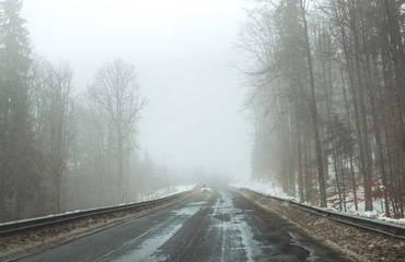 Foggy road in the mountains. Winter trip to the Carpathian Mountains, Eastern Europe