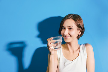 冷たい水を飲む女性（爽やかな青い背景）