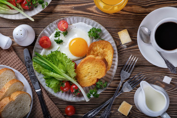 Fried eggs, croutons and salad with coffee and orange juice.