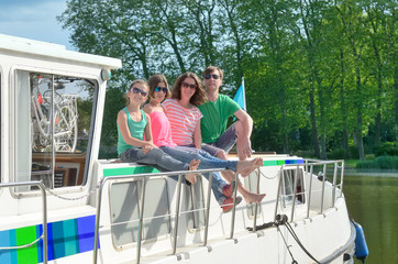 Family vacation, summer holiday travel on barge boat in canal, happy kids and parents having fun on river cruise trip in houseboat in France
