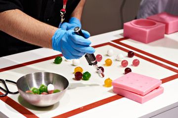 Confectioner with burner prepares color sweet balls