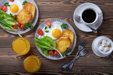 Fried eggs, croutons and salad with coffee and orange juice.
