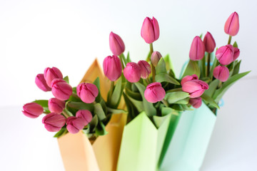 Bouquets of tulips in paper multi-colored packages. Spring gifts.