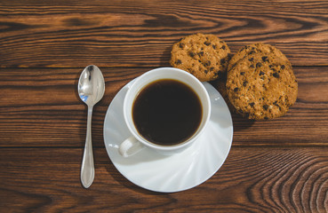 A cup of hot coffee stands on a wooden table 