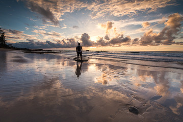 Fototapeta premium Rear view of a Man with beautiful reflection during sunset at Kudat, Sabah Malaysia.