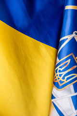 Realistic flag and emblem of Ukraine on the wavy surface of fabric