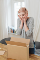 Overjoyed young woman with an open cardboard box