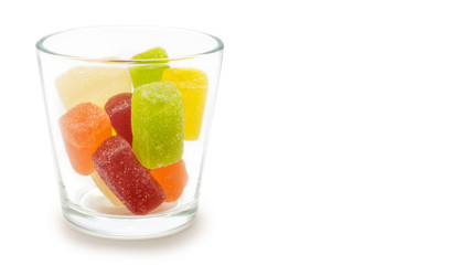 transparent glass with jelly candies. Isolated on white background. copy space, template.