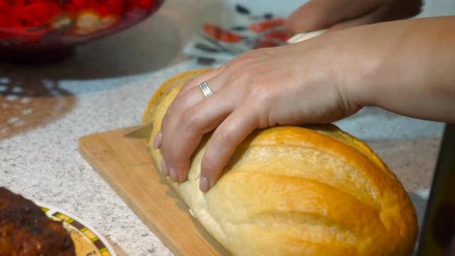 Woman cuts bread on cutting board