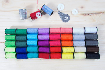 Obraz na płótnie Canvas Rainbow of colourful thread spools on the table