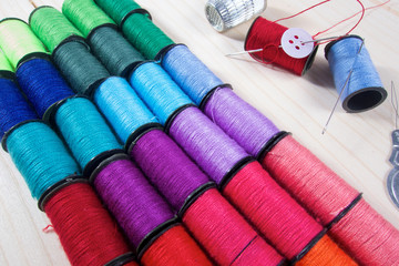 Rainbow of colourful thread spools on the table
