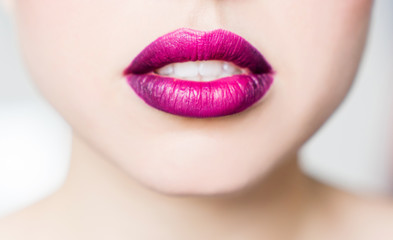 Bright female lips lipstick purple pink. Fashionable stylish youth color on the lips, close-up.