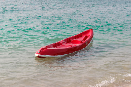 Small red boat on the beach.