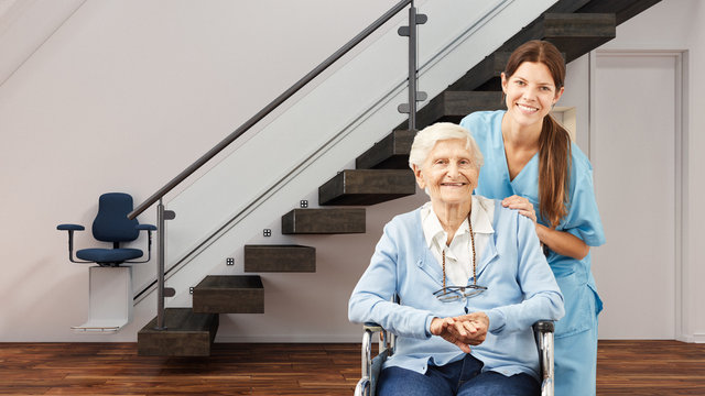 Seniorin und Krankenschwester im Haus mit Treppenlift