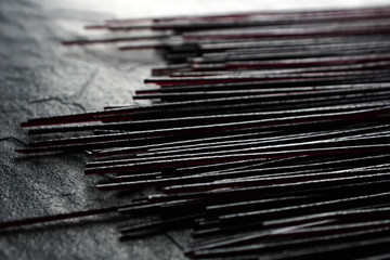 Black dry rice noodles on black stone close-up