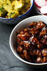 Pieces of teriyaki chicken, rice vermicelli and radish on a gray stone close-up. Asian cuisine