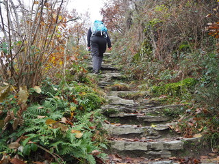 Wandernde Frau mit Rucksack geht eine Treppe hoch