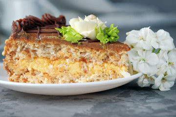 Slice of ukrainian Kiev cake on saucer. Homemade baking. Close-up view.
