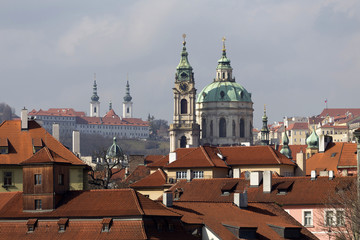 Obraz premium Early Spring Prague St. Nicholas' Cathedral with the Lesser Town above River Vltava in the sunny Day, Czech Republic