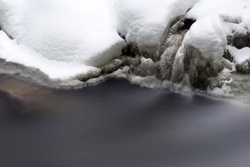 Stunning winter landscape, stones on wintry river covered snow