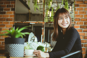 an Asia woman working,using mobile phone, computer with fun and happy in an office.business woman drinking coffee in free time.