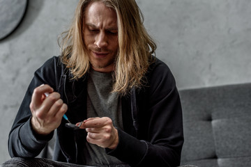 close-up shot of addicted junkie boiling heroin in spoon with lighter