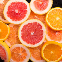 Slice citrus: orange, mandarin and grapefruit on brown wooden background