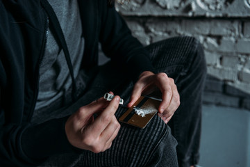 cropped shot of addicted junkie sniffing cocaine from credit card