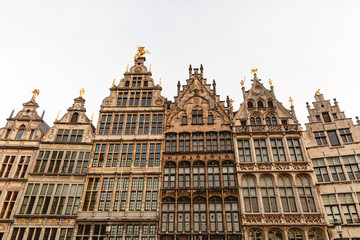 Fototapeta na wymiar low angle view of beautiful buildings with statues in historic quarter of Antwerp, Belgium