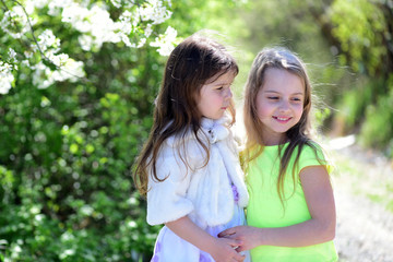 Fototapeta premium Girls with happy and serious faces hug each other