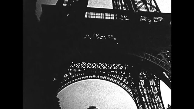 Paris Eiffel Tower, bottom view from Champ de Mars gardens. Historic restored BW archival footage on 1960 in Paris city of France.