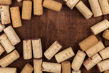 Wine corks on dark wooden texture, frame with copyspace