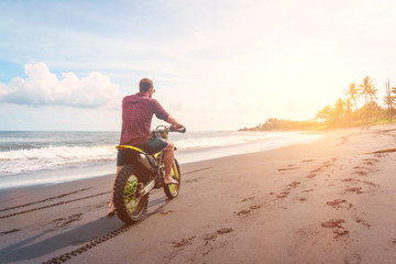 A man rides his mountain bike on a beach in Bali