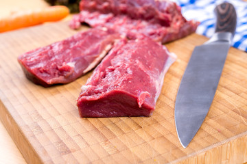 saddle of venison on wooden board