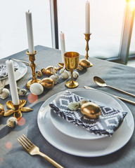 festive table with golden eggs and candles, easter concept