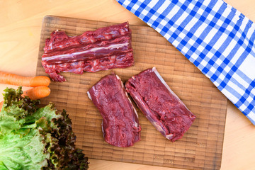 saddle of venison on wooden board