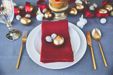 high angle view of golden egg and quail eggs on plate in restaurant, easter concept