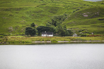 Fototapeta na wymiar Alone white house on the bank of the lake in Ireland