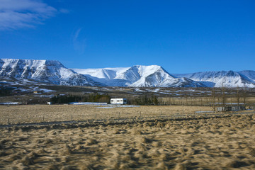 Winter meadow landscape with the snow rocks on the background 