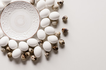 food composition with chicken and quail eggs around plate on white