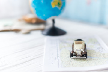 Small car on the map. The concept of travel