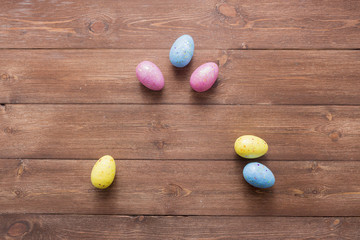Happy easter eggs on color for holiday on wooden background top view flat lay