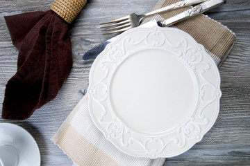 Nice vintage ceramic plate with silver fork and knife on wooden table