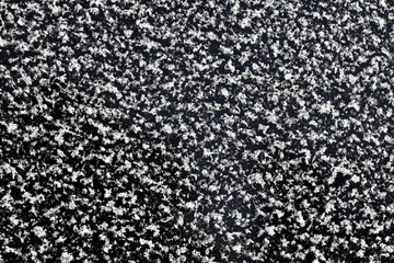 white snow flakes on a dark glass frosty texture pattern