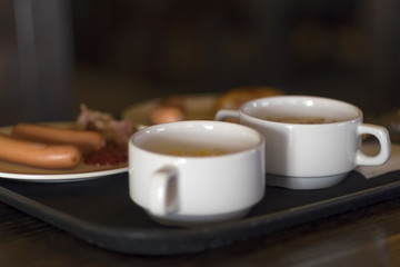 Sausages with fried potatoes on a tray, part of the breakfast in