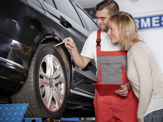 Mechaniker und Kundin in der Werkstatt 