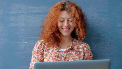 Portrait of a woman with a red hair working on a laptop. - Powered by Adobe